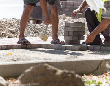 İşçi yola kaldırım taşı koyar .