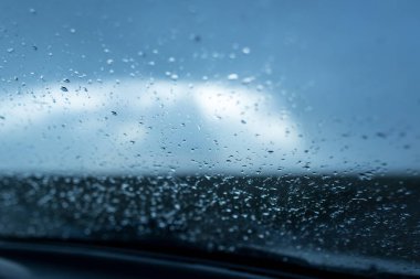 Arabanın ön camına yağmur damlaları. Soyut bir dokunun fotoğrafı