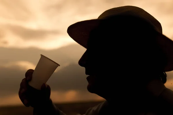夕日を背景に水を飲む男のシルエット — ストック写真