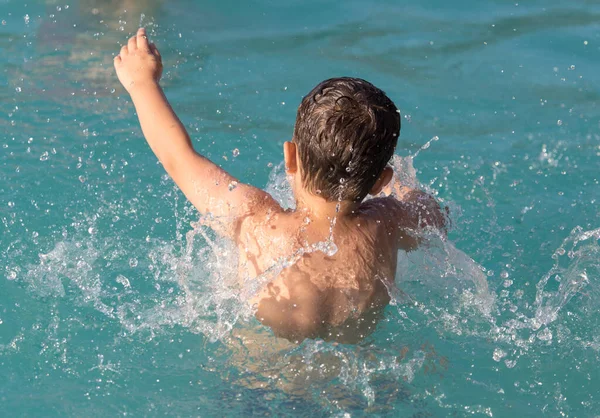 少年はウォーターパークでスプラッシュで泳いでいます — ストック写真