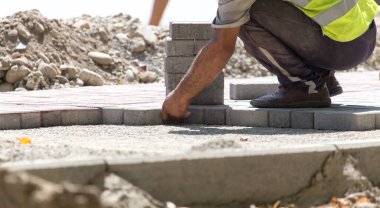 İşçi yola kaldırım taşı koyar .