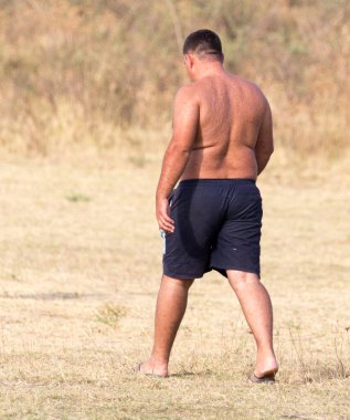 Açık havada şortlu şişman bir adam. Doğadaki parkta.