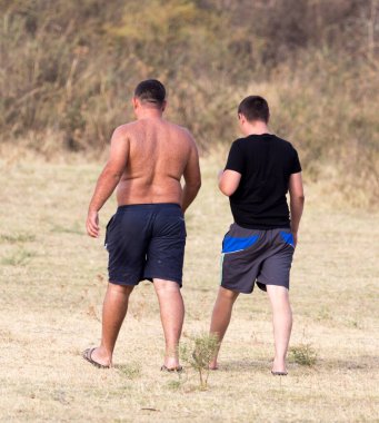 Açık havada şortlu iki adam. Doğadaki parkta.