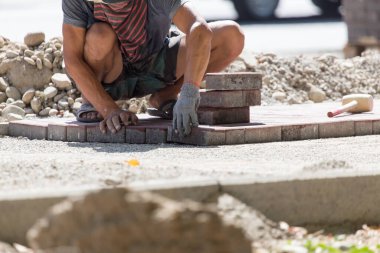 İşçi yola kaldırım taşı koyar .