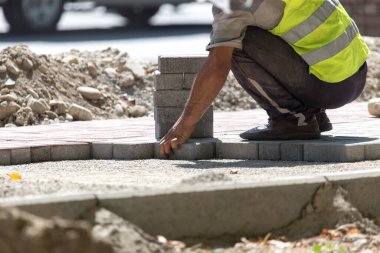 İşçi yola kaldırım taşı koyar .