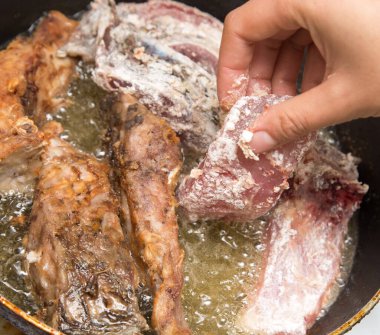 Balık tavada kızarır. Fotoğraflar stüdyoda.