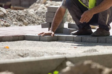 İşçi yola kaldırım taşı koyar .