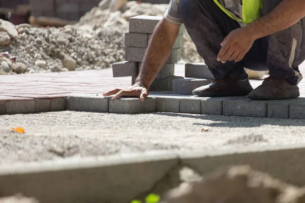 İşçi yola kaldırım taşı koyar .