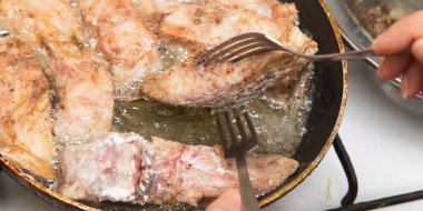 Balık tavada kızarır. Fotoğraflar stüdyoda.