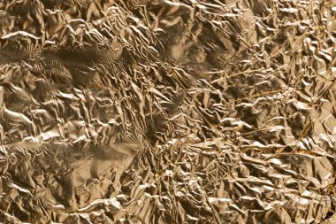 Arkaplan olarak altın folyo. Soyut bir dokunun fotoğrafı