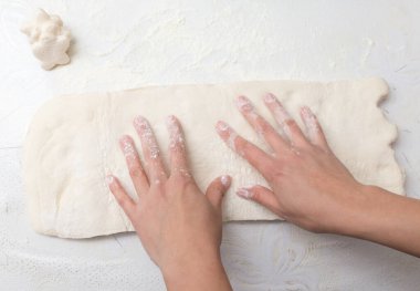 Mutfakta hamuru yuvarlıyor. Fotoğraflar stüdyoda.