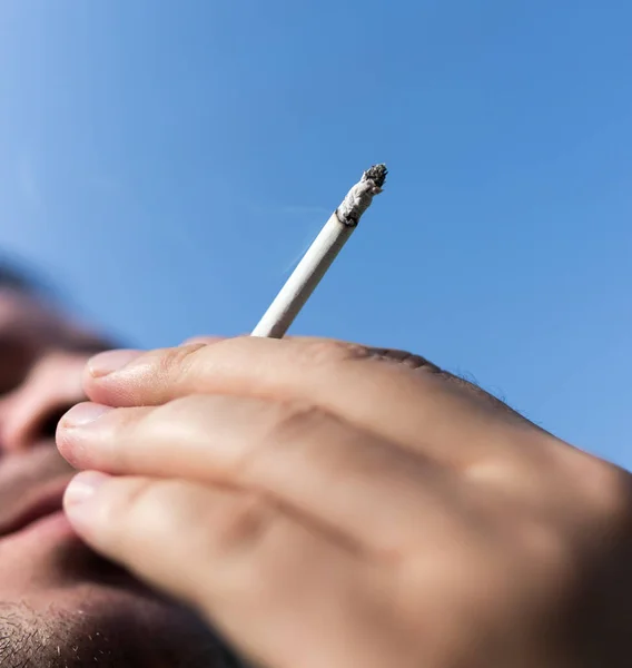 Sigaretta Mano Contro Cielo Blu — Foto Stock