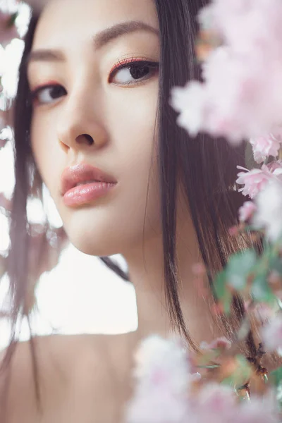 Retrato de una hermosa fantasía chica asiática al aire libre contra el fondo natural de la flor de primavera . — Foto de Stock