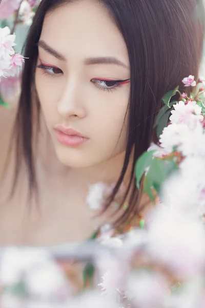 Retrato de una hermosa fantasía chica asiática al aire libre contra el fondo natural de la flor de primavera . — Foto de Stock