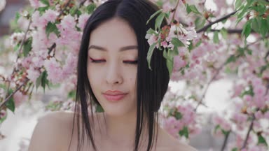 Açık havada ağaç bahar çiçeği karşı güzel bir Asyalı kız portresi.