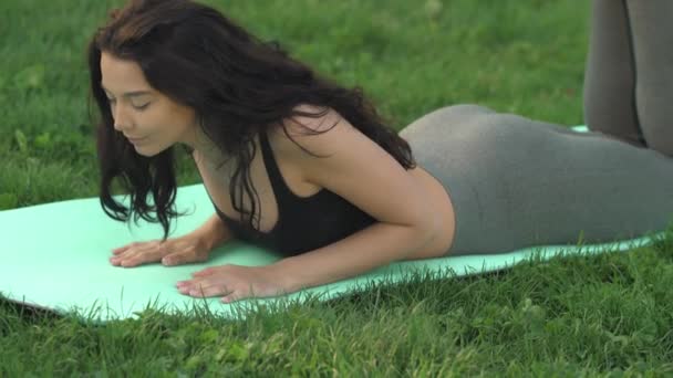 Kobieta ćwiczy jogę na świeżym powietrzu w parku — Wideo stockowe