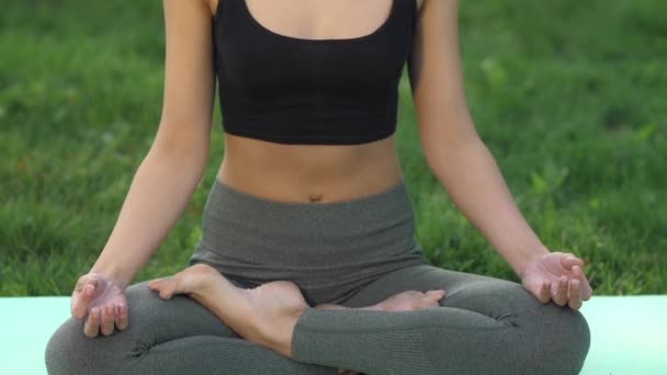 Женщина практикует йогу на открытом воздухе в парке — стоковое видео