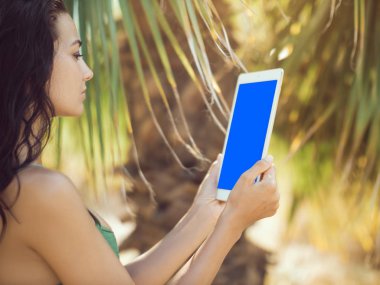 Tablet bilgisayar kullanan Gezgin kadın.