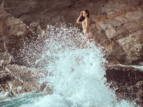 Güzel genç kadın vahşi kayalık plaj.