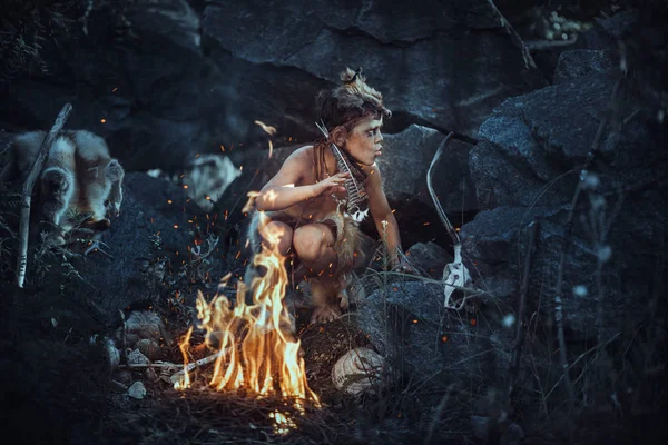 火のシャーマンの少年 屋外の焚き火近く怖い若い原始少年 ウィッチ クラフトのコンセプトです 怒っている穴居人 たき火の近くの角で男らしい少年 自然に屋外の先史時代の部族の男 — ストック写真
