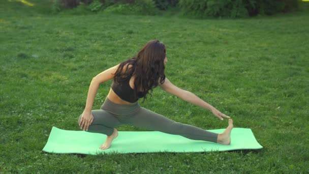 Mujer joven haciendo ejercicio para estirar el cuerpo . — Vídeos de Stock