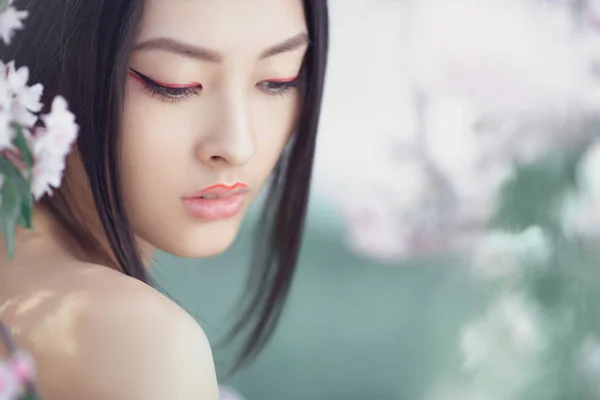 Portrét krásné fantasy asijské dívky venku pozadí přírodní jarní květ. — Stock fotografie