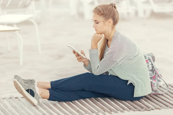 Žena se smartphonem na pláži. Dovolená a technika. — Stock fotografie