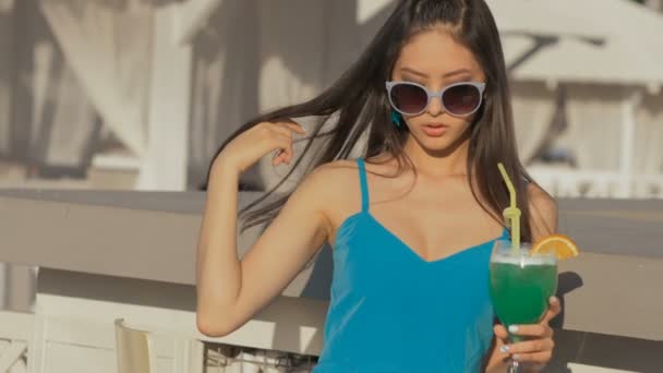 Giovane donna di moda asiatica bere cocktail in un bar sulla spiaggia . — Video Stock