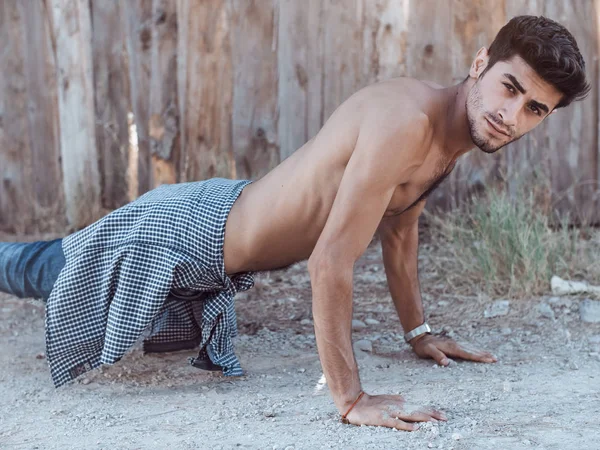 Photo d'un jeune homme athlétique faisant des pompes à l'extérieur . — Photo