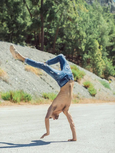 Young man break dancing on the road.