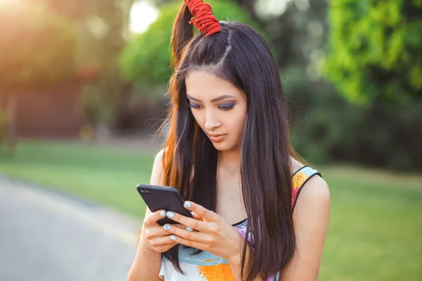 Felice giovane donna asiatica con smartphone in piedi in strada — Foto Stock