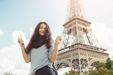 Genç çekici mutlu kadın barış hareketi Eyfel Kulesi Paris, Fransa'da gösterilen