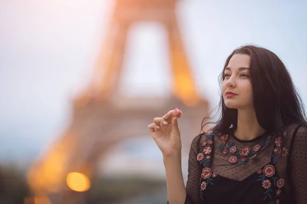 Paris kobieta uśmiecha się jedząc francuski makaron ciasta w Paryżu przeciwko wieży Eiffla. — Zdjęcie stockowe