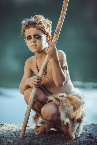 Cute caveman, manly boy with staff hunting outdoors. Ancient warrior — Stock Image Cute caveman, manly boy with staff hunting outdoors. Ancient warrior Stock Image