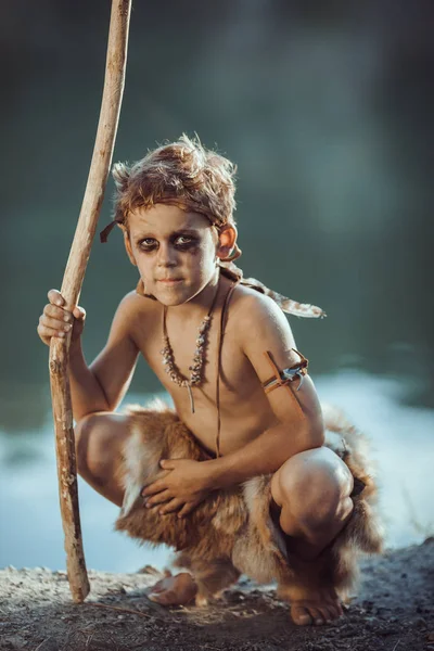 Cute caveman, manly boy with staff hunting outdoors. Ancient warrior — Stock Image Cute caveman, manly boy with staff hunting outdoors. Ancient warrior Stock Picture