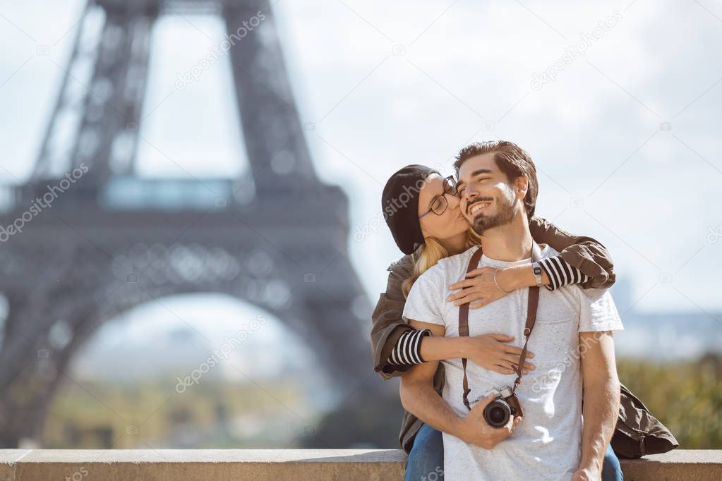Paris Eiffel tower romantic couple embracing kissing in front of Eiffel Tower, Paris, France.