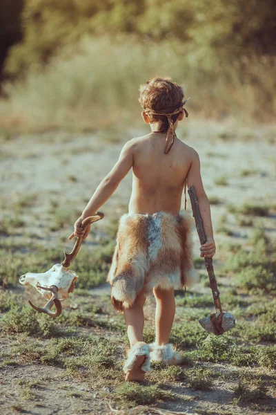 Caveman, manly boy with primitive weapon outdoors. Ancient prehistoric warrior. — Stock Image Caveman, manly boy with primitive weapon outdoors. Ancient prehistoric warrior. Stock Photo