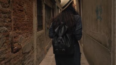 Genç kız Venedik dar sokaklarında yürüyor