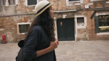 Genç kız Venedik dar sokaklarında yürüyor