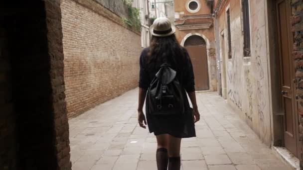 Молодая девушка ходит по узким улочкам Венеции — стоковое видео