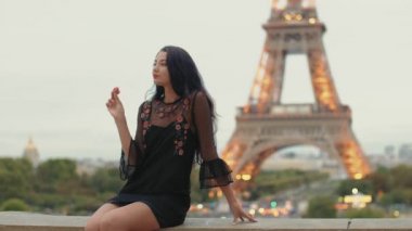 Paris 'te Eiffel Kulesi' ne karşı Fransız pastası yiyen Paris 'li kadın gülümsüyor..