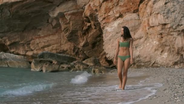 Jeune femme attrayante marchant sur la plage — Video