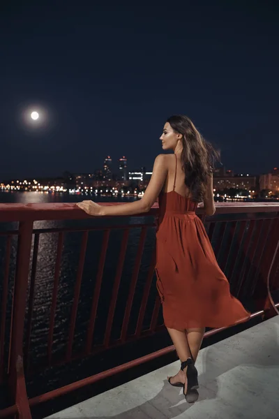 Молодая женщина-эллигант, стоящая на фоне ночного города. Свобода и девушка в любви — стоковое фото