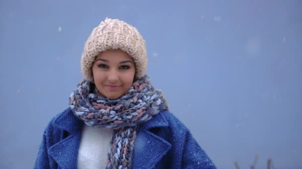 一个面带微笑的女人在冬天的背景下竖起大拇指的肖像。冬季概念。雪和女人 — 图库视频影像