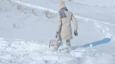 Dik bir tepeden aşağı bir kızak üzerinde sürme kadın.