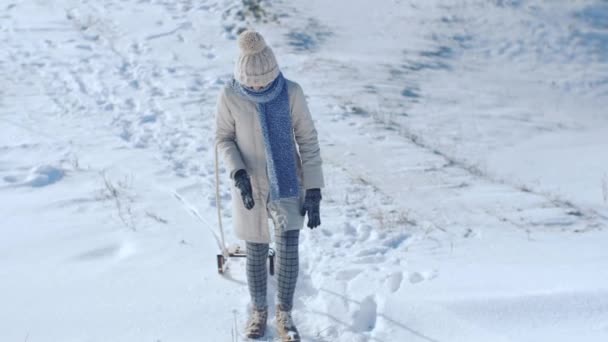 Замерзшая смешная женщина тащит санки на улицу — стоковое видео