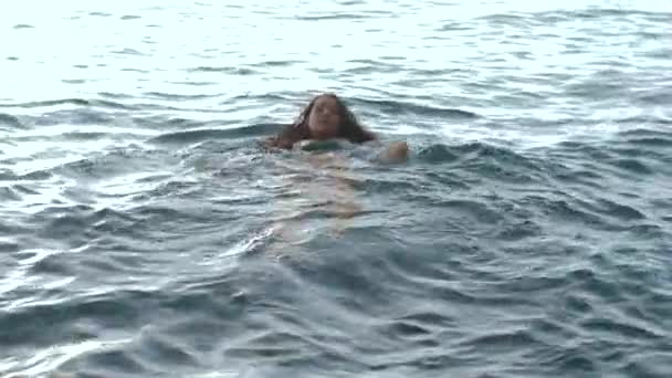 Slowmotion: Kvinna simmar i havet. — Stockvideo