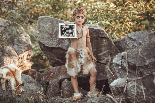 Пещерный человек, мужественный мальчик, держащий планшет PC — стоковое фото