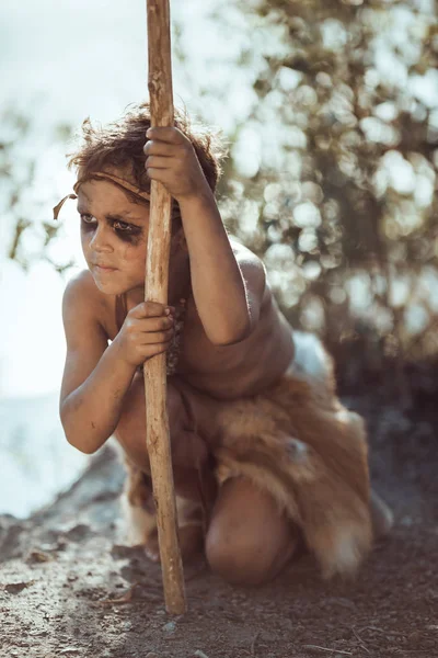 Tired caveman, manly boy with staff hunting outdoors. Ancient warrior — Stock Image Tired caveman, manly boy with staff hunting outdoors. Ancient warrior Stock Photo
