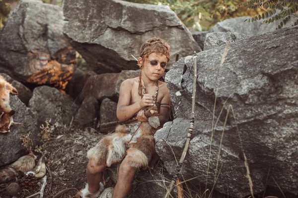 Barlanglakó ősember, férfias fiú így primitív kő fegyver-táborban — Stock Fotó